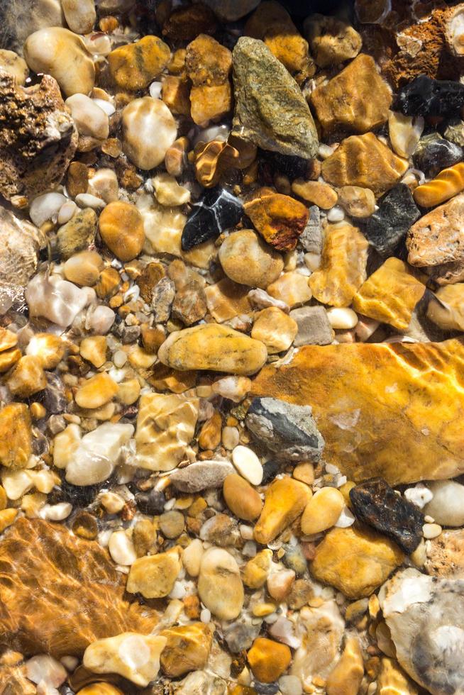 Guijarros de colores bajo el agua para el fondo foto