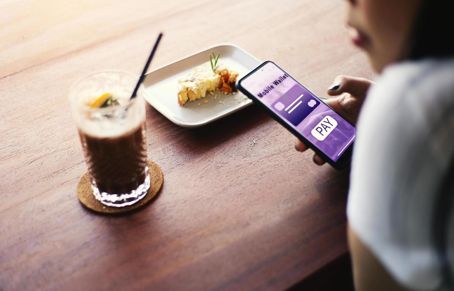 Person using mobile phone payment in a cafe photo