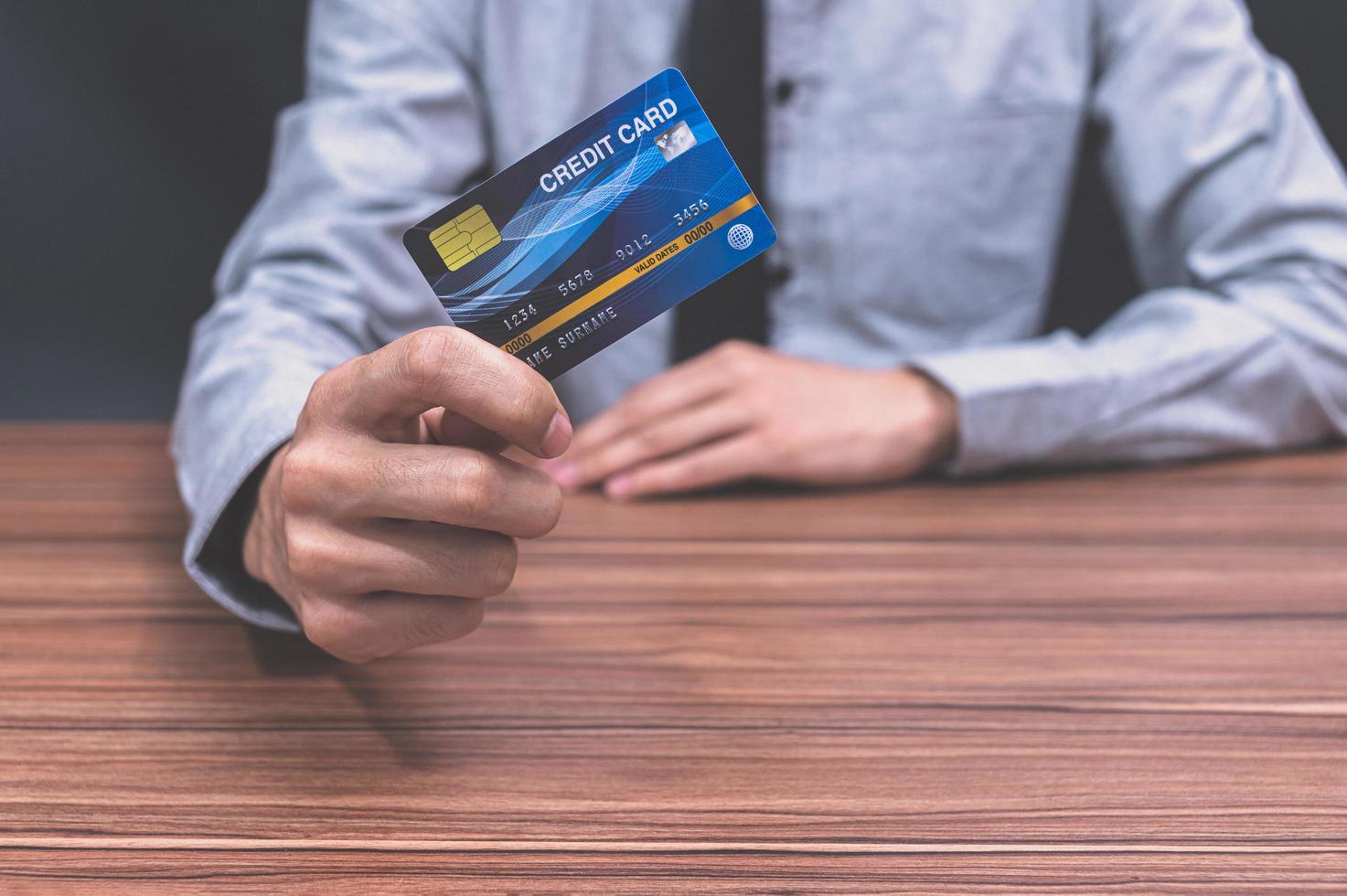 hombre sosteniendo una tarjeta de crédito azul foto