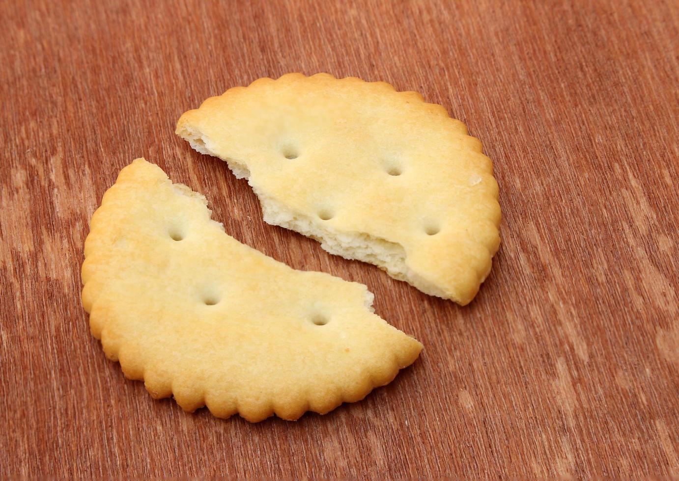 Broken cracker on wood photo