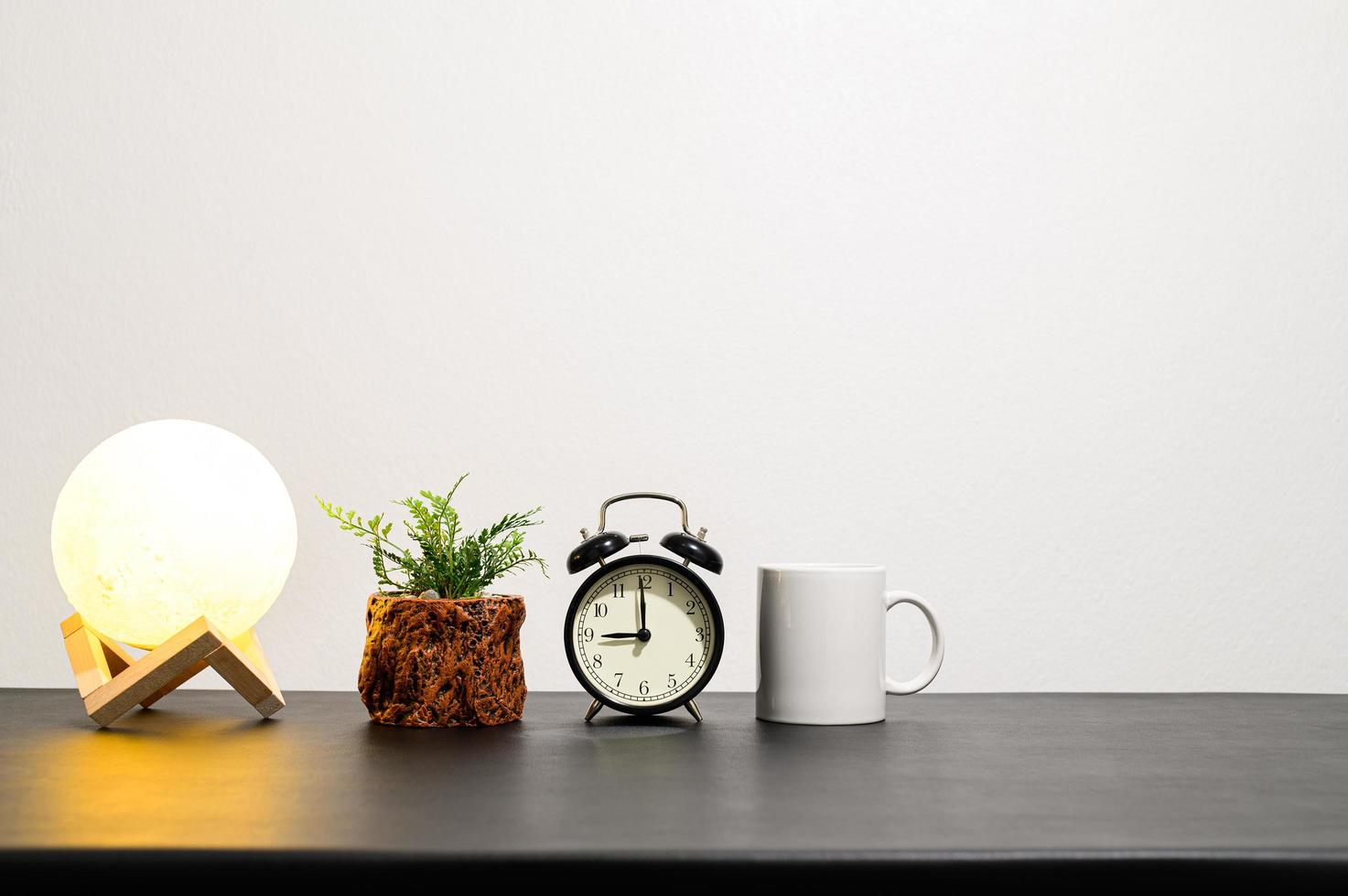 lámpara con una planta, reloj y taza foto