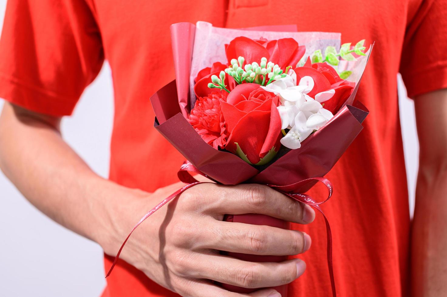 persona vestida de rojo sosteniendo flores foto