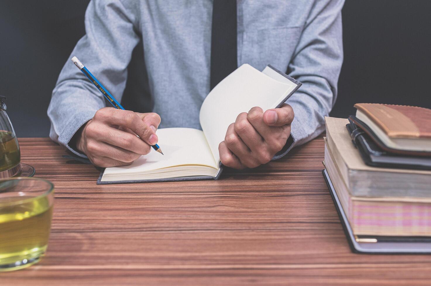 Person writing in book photo