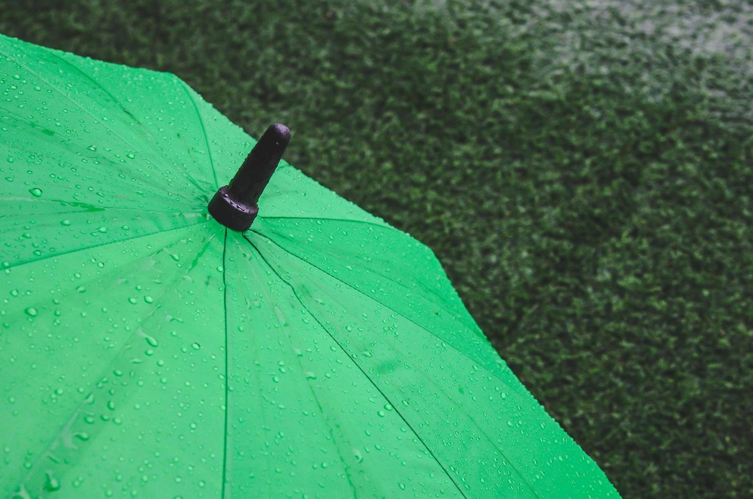 paraguas verde con gotas de lluvia foto