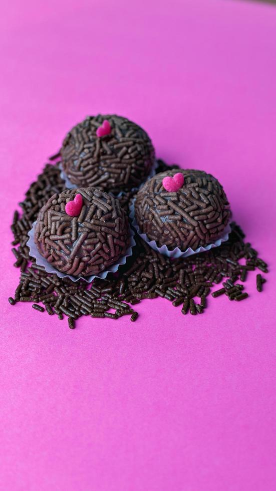 Chocolate truffles on pink background photo