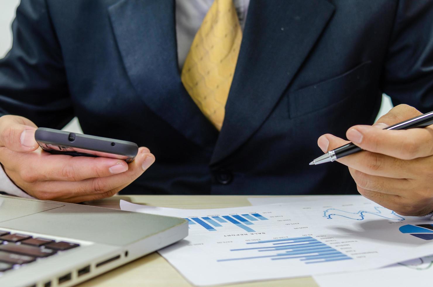 Hombre de negocios financieros analizando gráficos en un escritorio foto