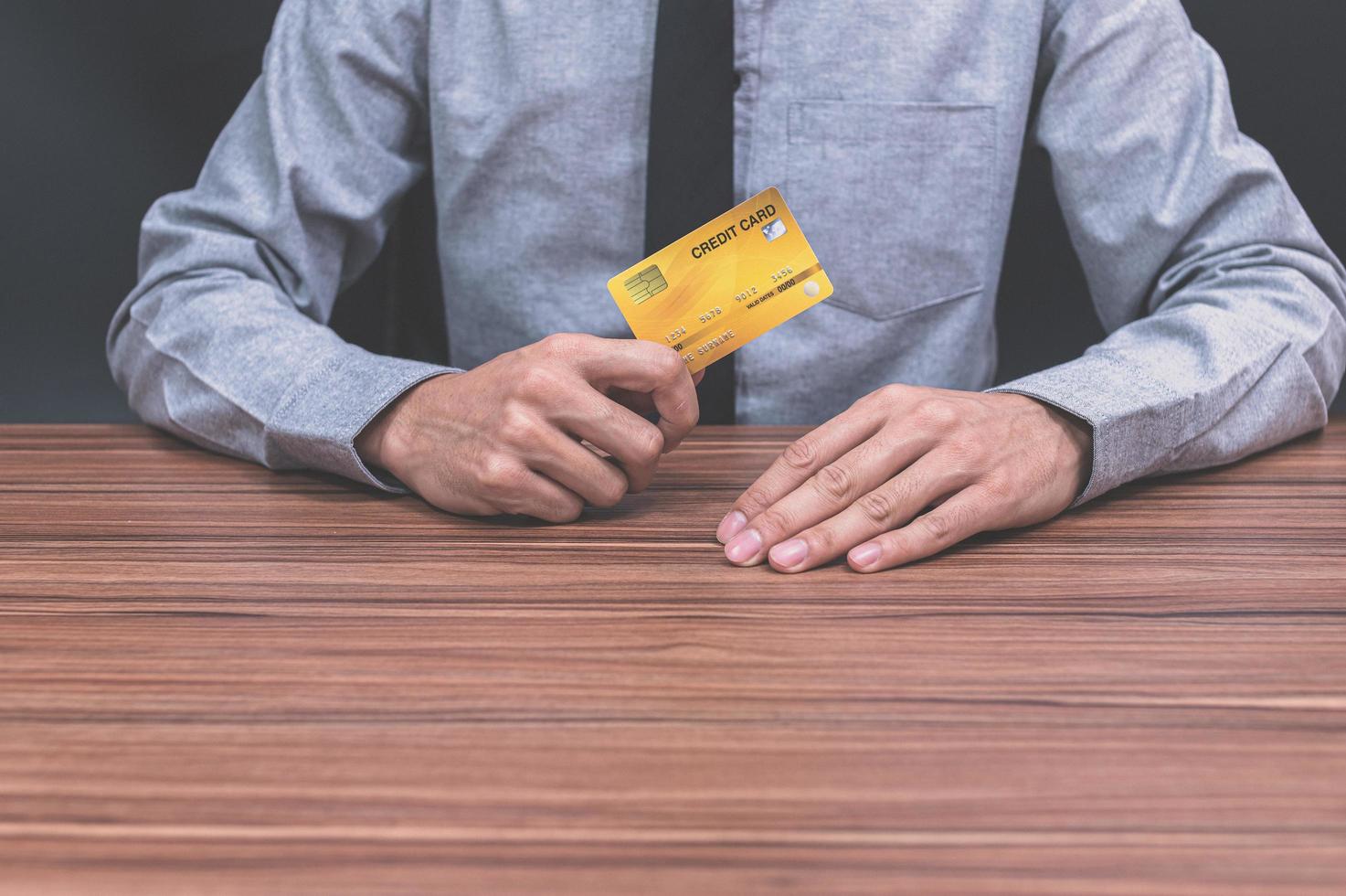 Person holding a credit card at a desk photo