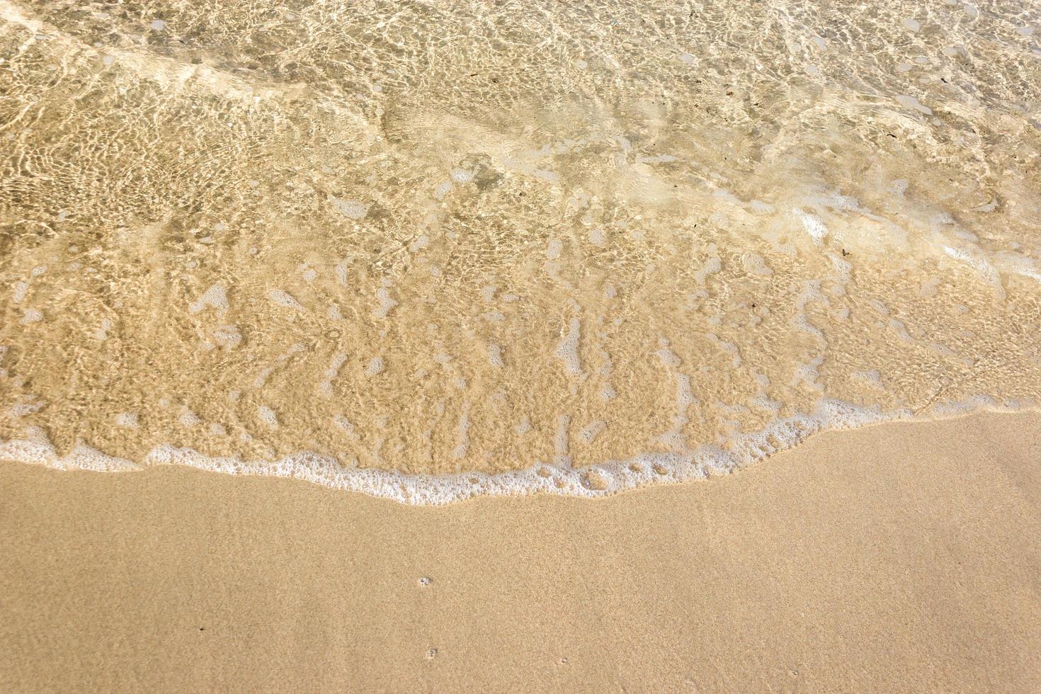 olas del mar en la playa de arena foto