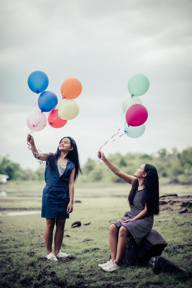 Grupo de novias felices sosteniendo globos multicolores en un parque foto