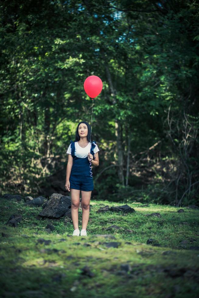 Young girl holding colorful balloons in nature photo