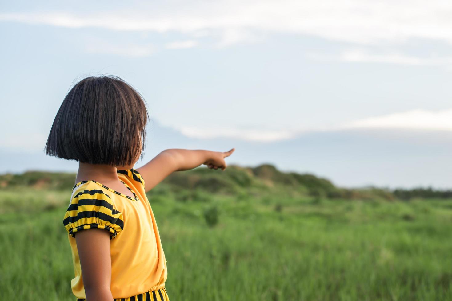 Girl pointing her hand to the sky photo