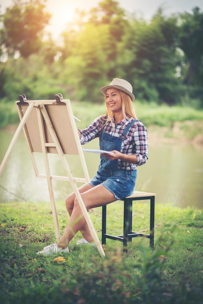 Young woman draws a picture in the park photo