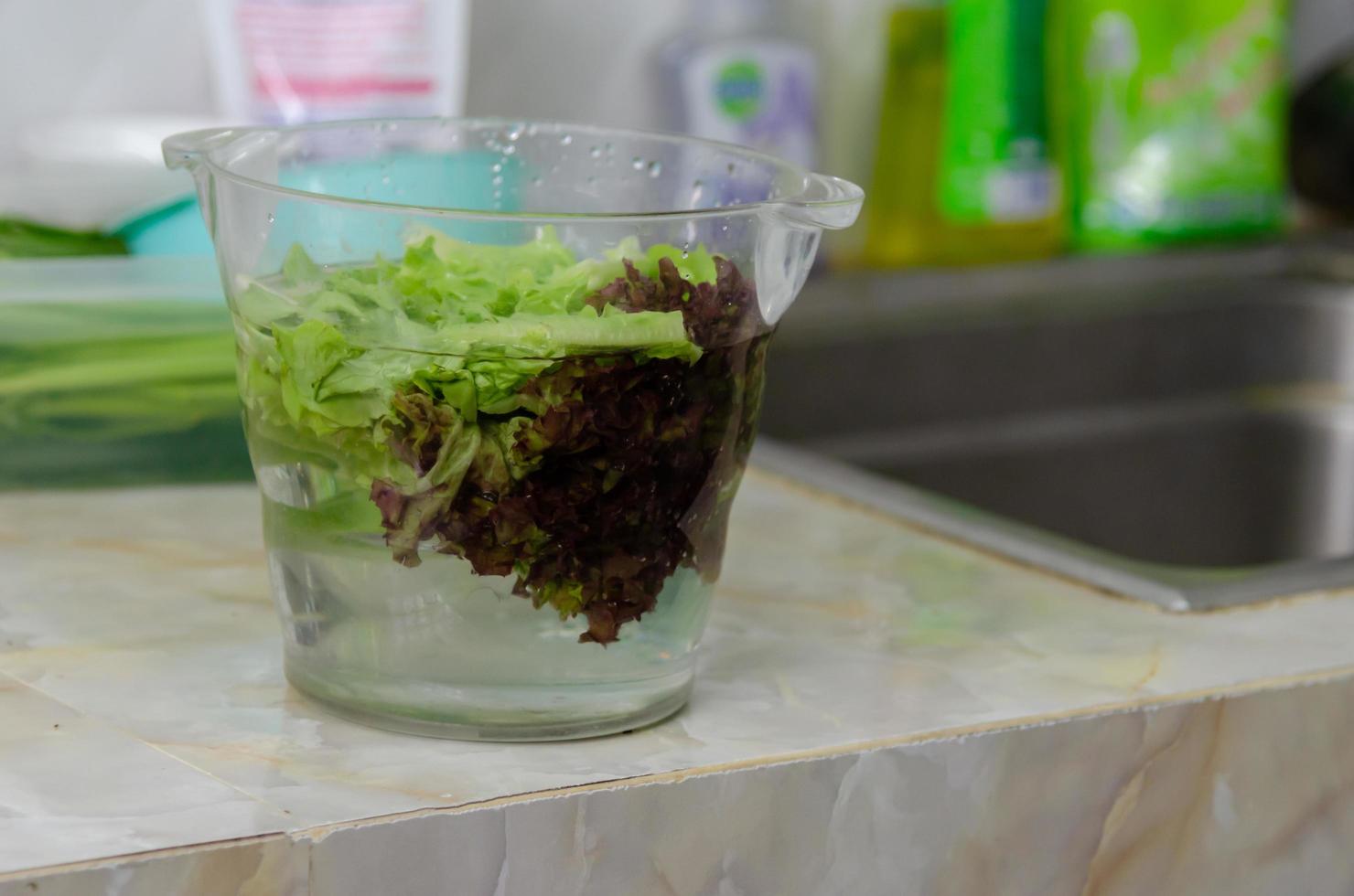 Washing lettuce in a glass bowl photo