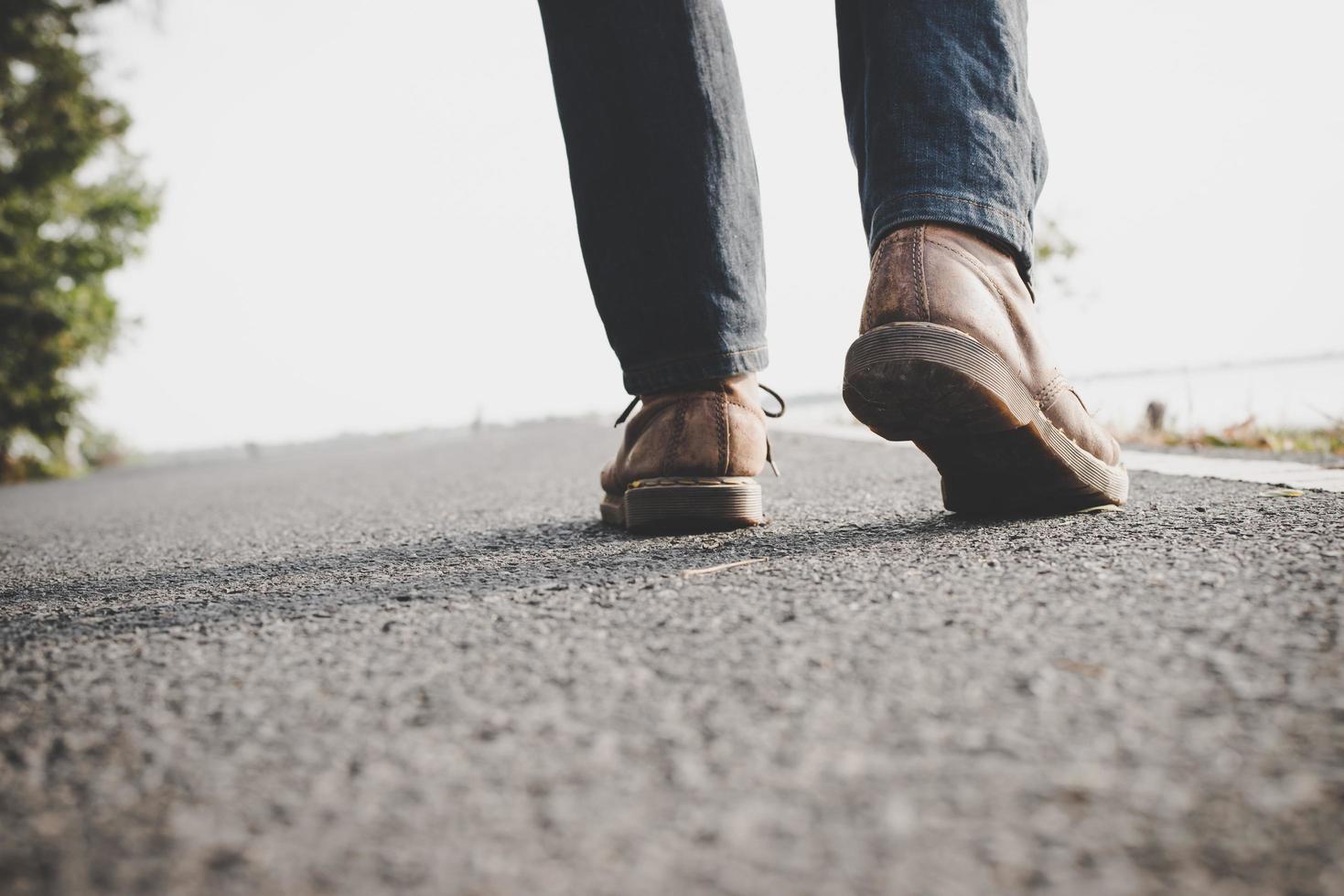 Close-up of young tourist man walking on a countryside road photo