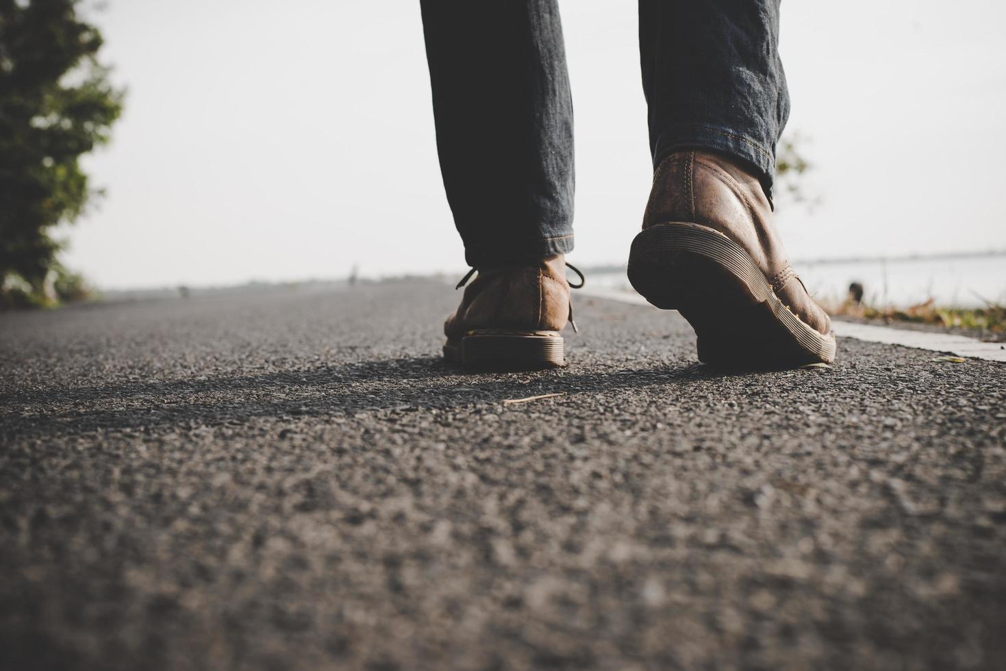 Close-up of young tourist man walking on a countryside road photo