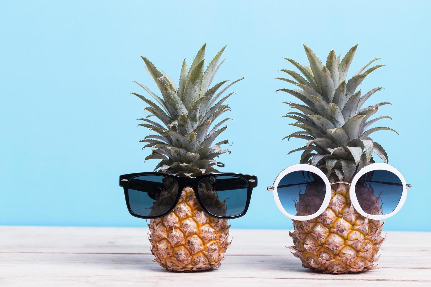 Two pineapples wearing sunglasses photo