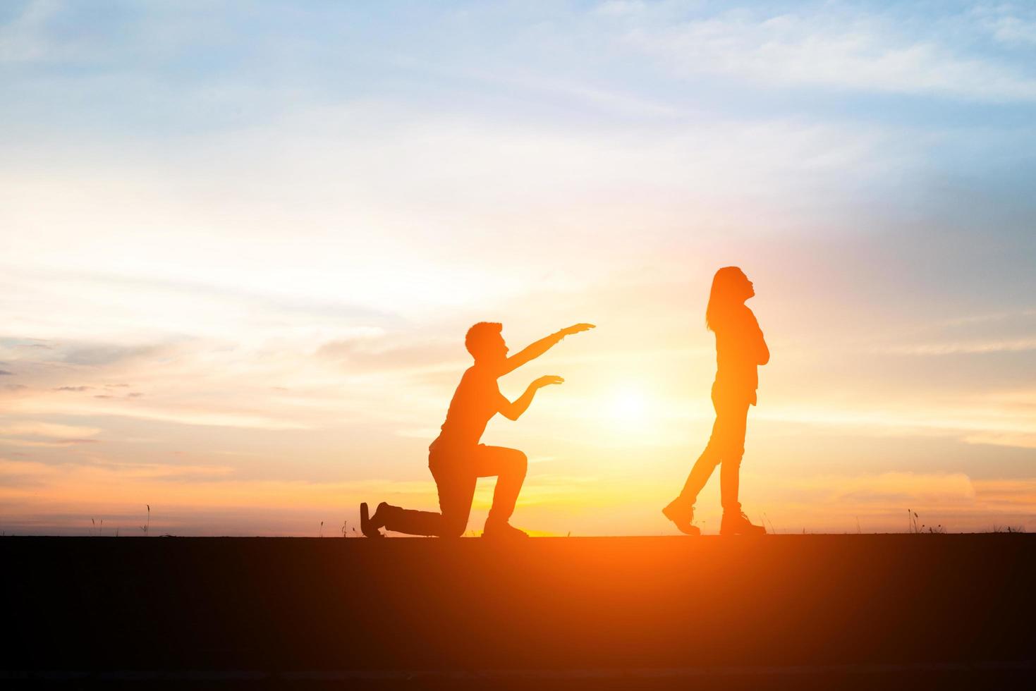 Silhouette of an upset couple in a quarrel at sunset photo