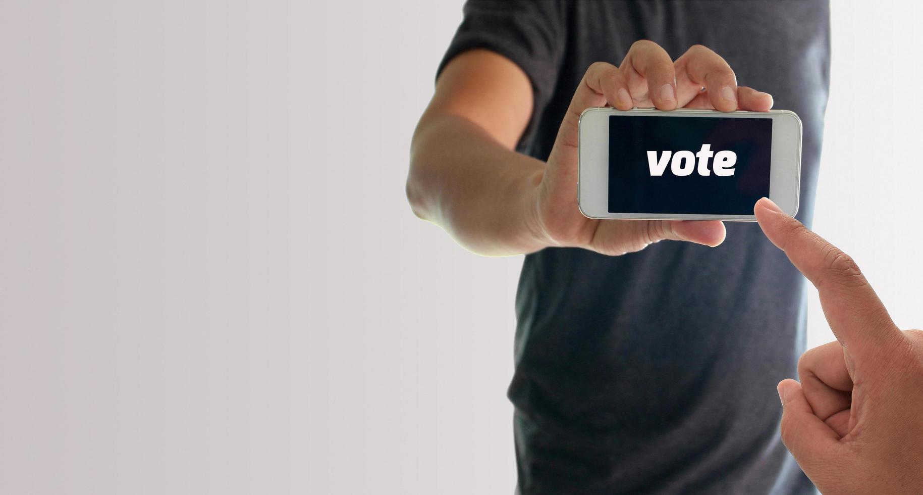 hombre sujetando el teléfono con voto en la pantalla foto