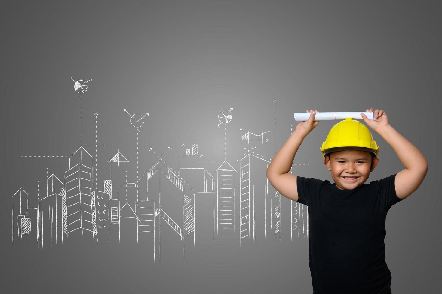 Joven con un sombrero de ingeniero amarillo e ideas del plan de la casa en una pizarra foto