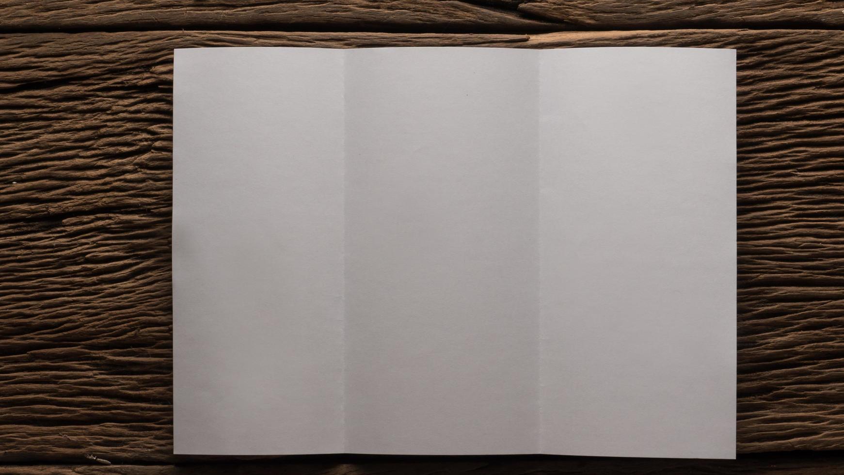 White blank folded paper on wooden table photo