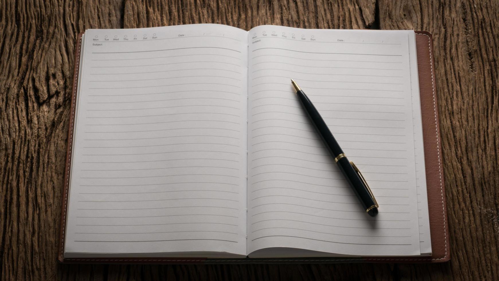 Image of an open blank notebook on wooden table photo