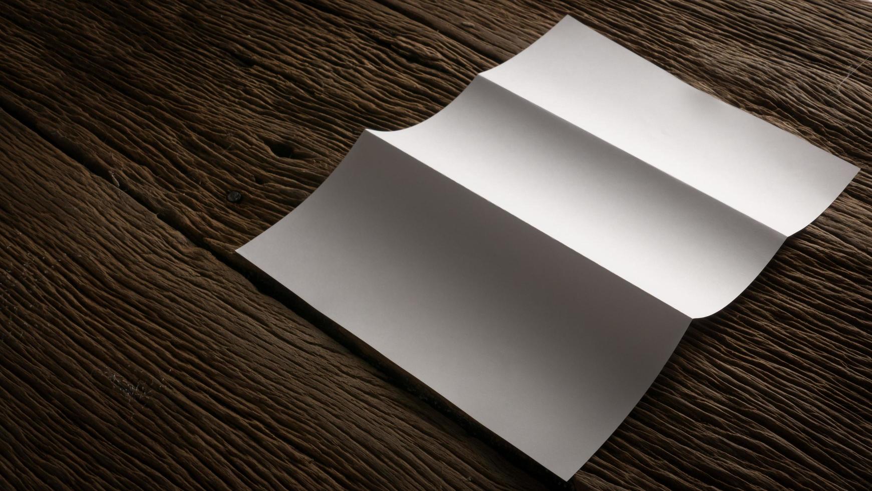 White blank folded paper on wooden table photo