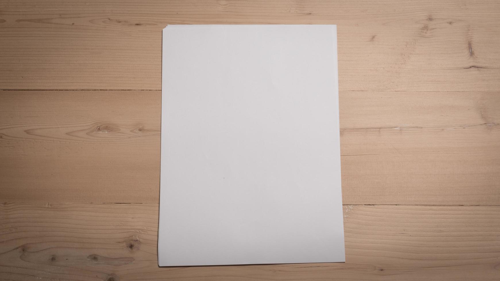 Papel doblado en blanco blanco sobre mesa de madera foto