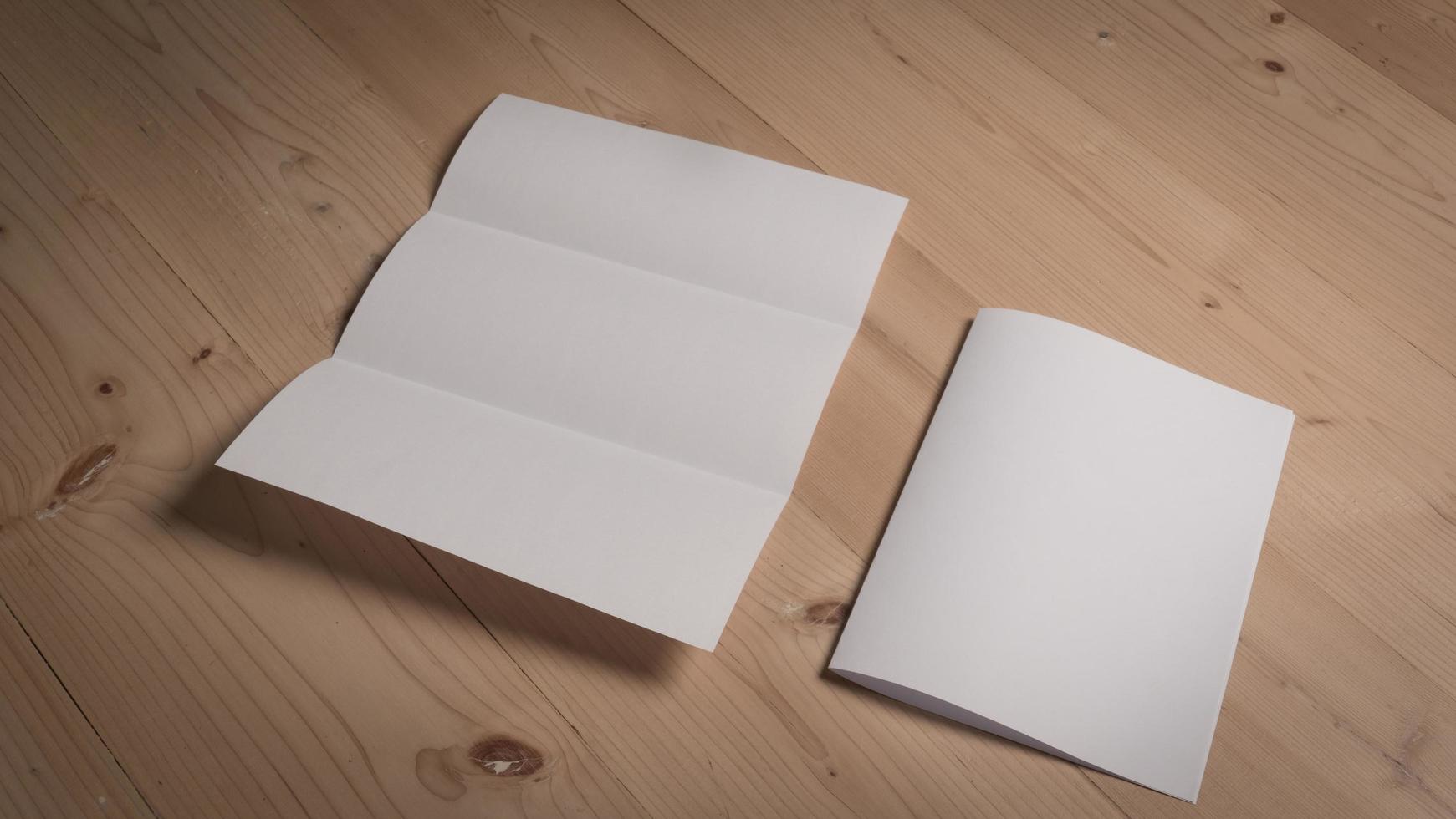 Papel doblado en blanco blanco sobre mesa de madera foto