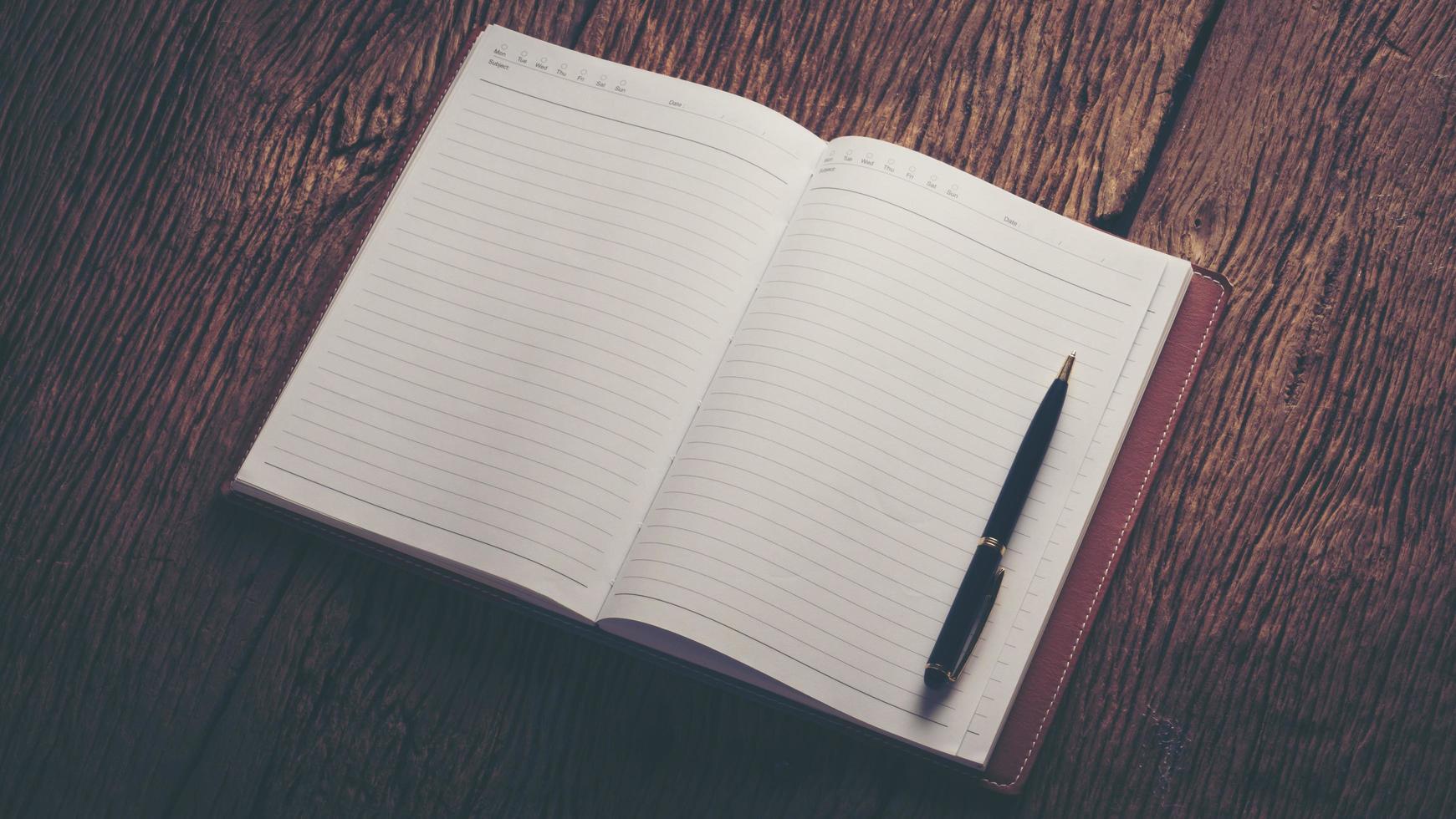 Image of an open blank notebook on wooden table photo