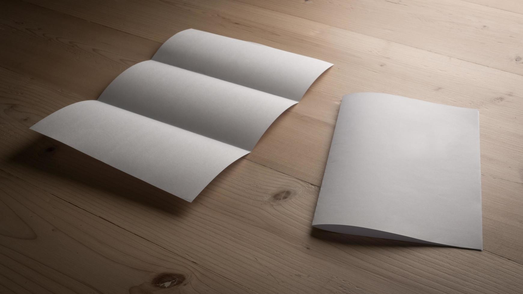 White blank folded paper on wooden table photo