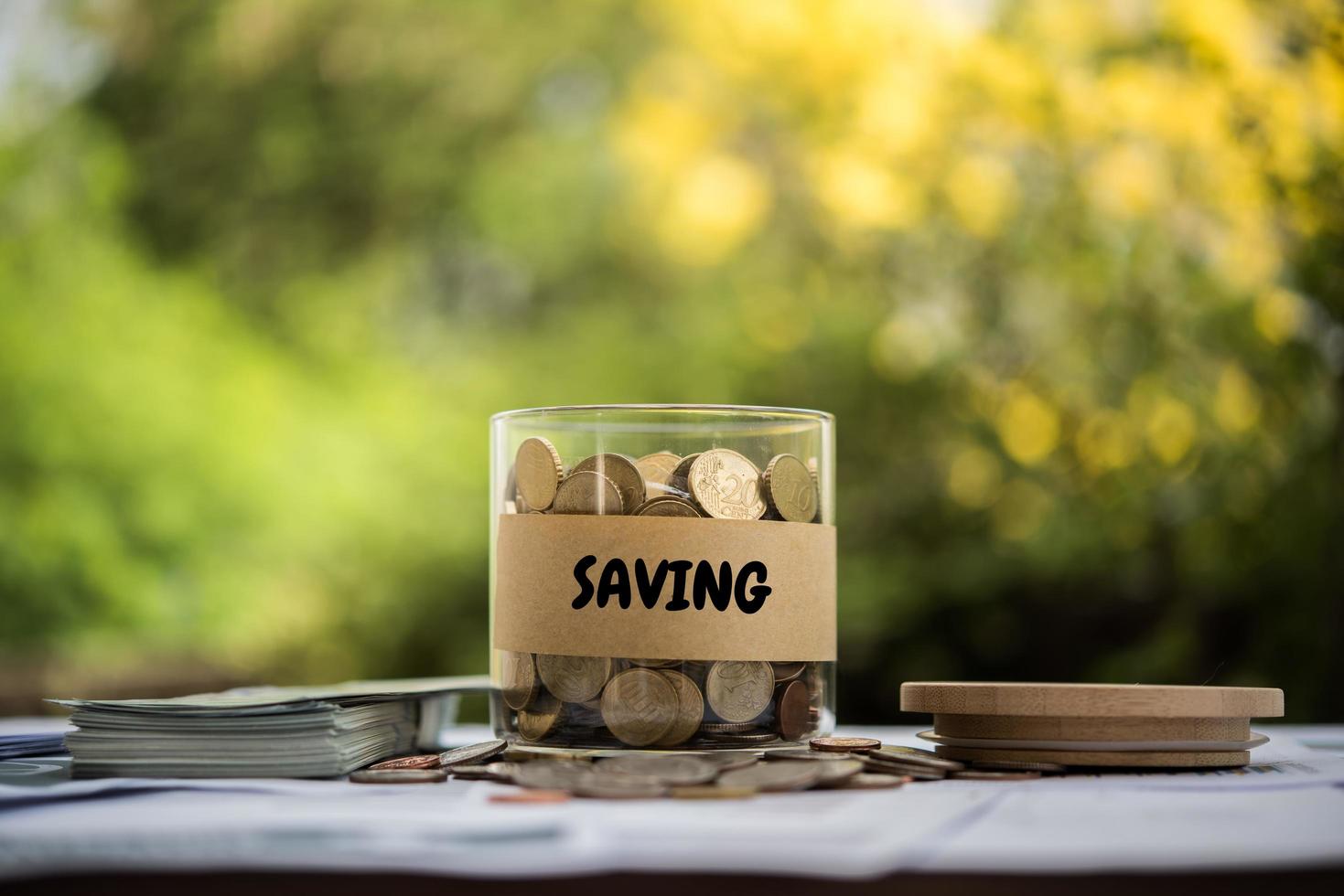 dinero en un frasco de vidrio en la naturaleza, concepto de inversión foto