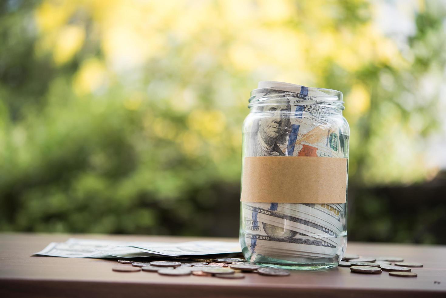 Money in a glass jar in nature, investment concept photo