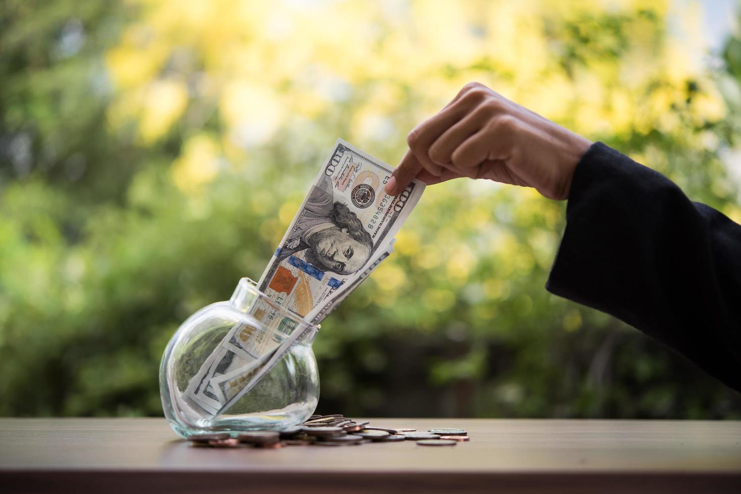 Money in a glass jar in nature, investment concept photo