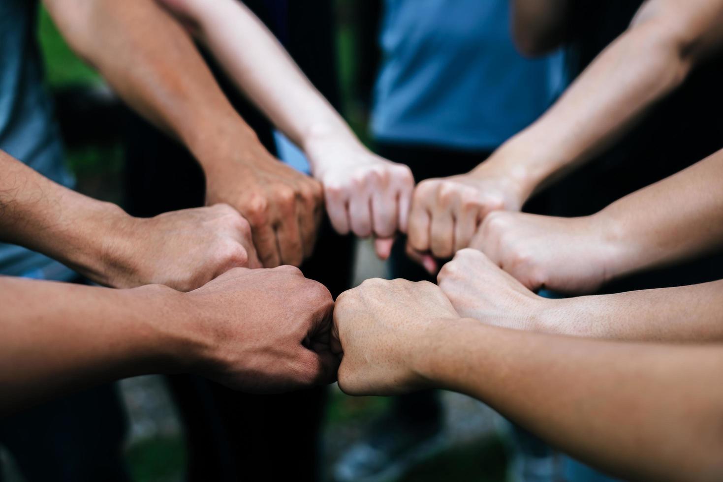 Close-up of multiethnic group standing with hands together photo