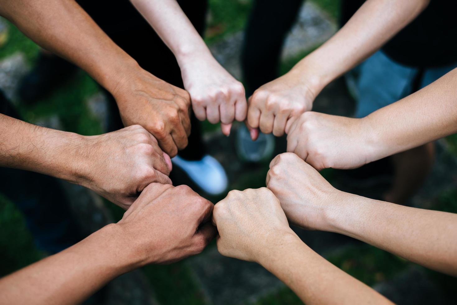 Close-up of multiethnic group standing with hands together photo