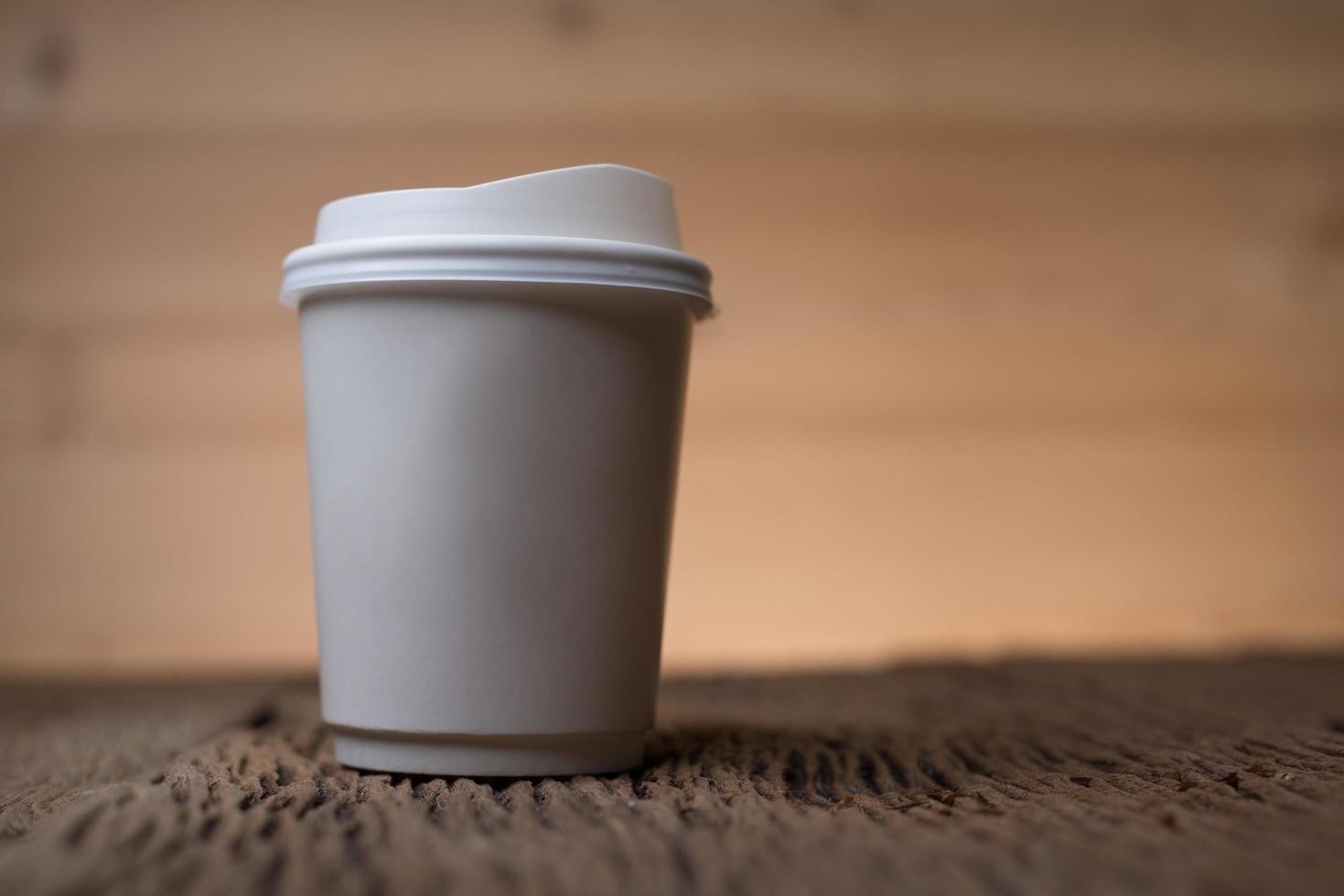 Blank paper coffee cup on wooden table photo