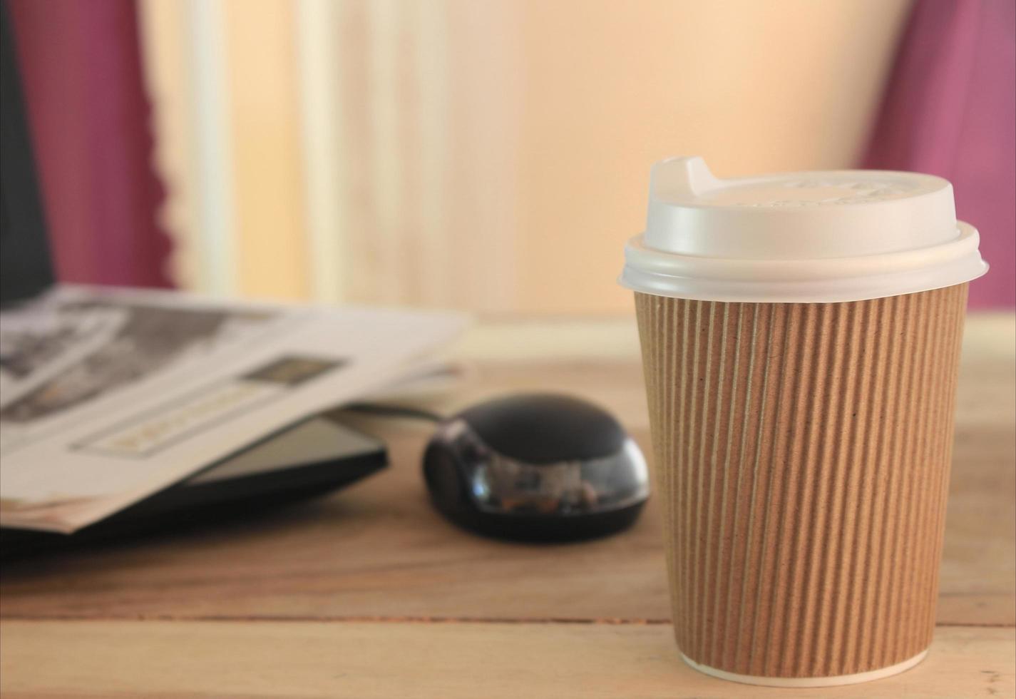 taza para llevar en el escritorio de madera foto