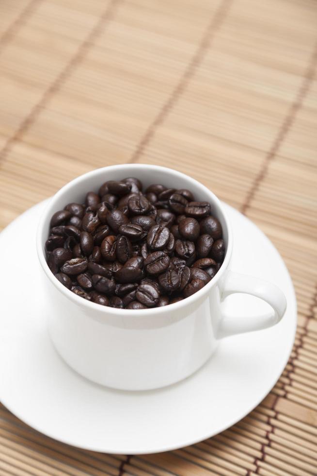 granos de café tostados en una taza foto