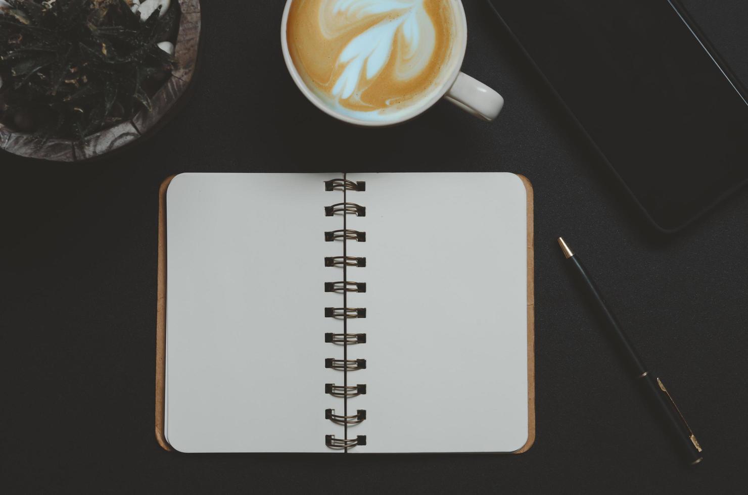 Top view of an open notebook and a latte photo