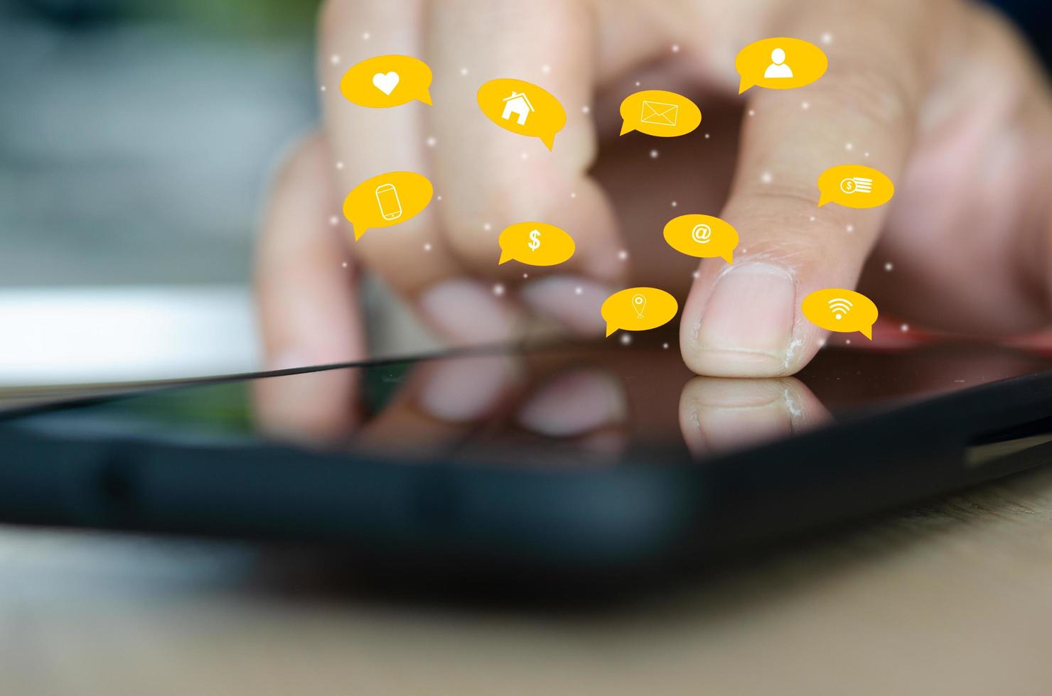 Finger touching smart phone with digital icons overlay photo