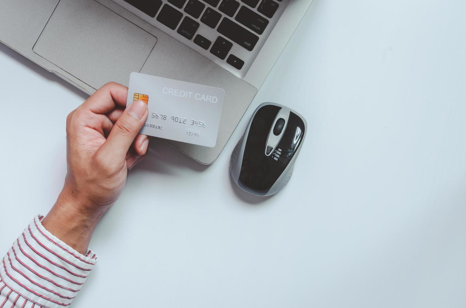 Hand holding credit card on a desk photo