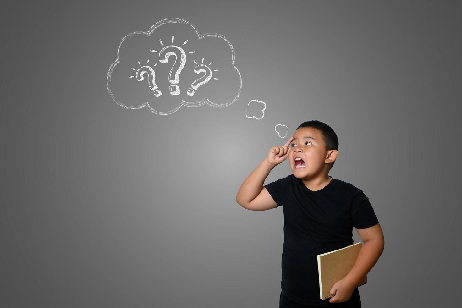 Confused young boy on neutral chalkboard background photo