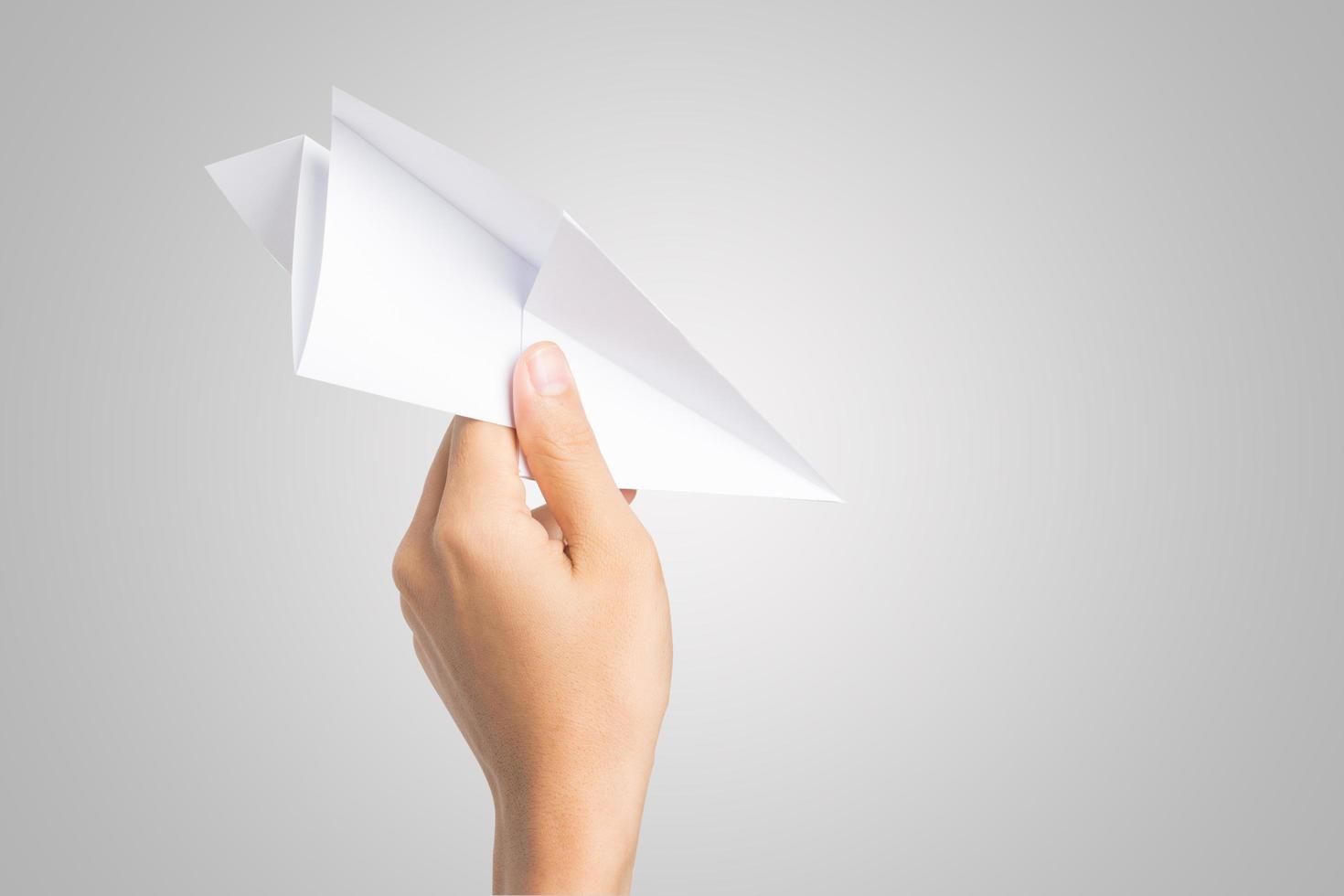 Mano de mujer sosteniendo un avión de papel aislado sobre fondo blanco. foto