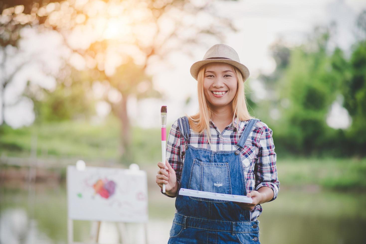 Beautiful girl drawing a picture in the park photo