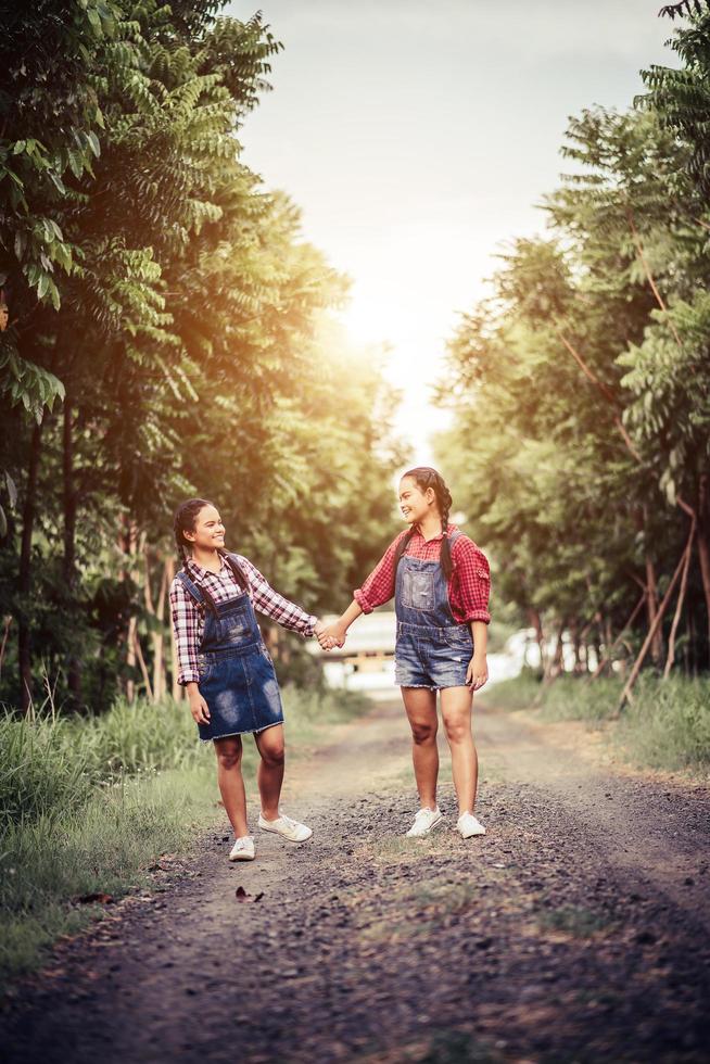 dos niñas caminando por un camino forestal foto