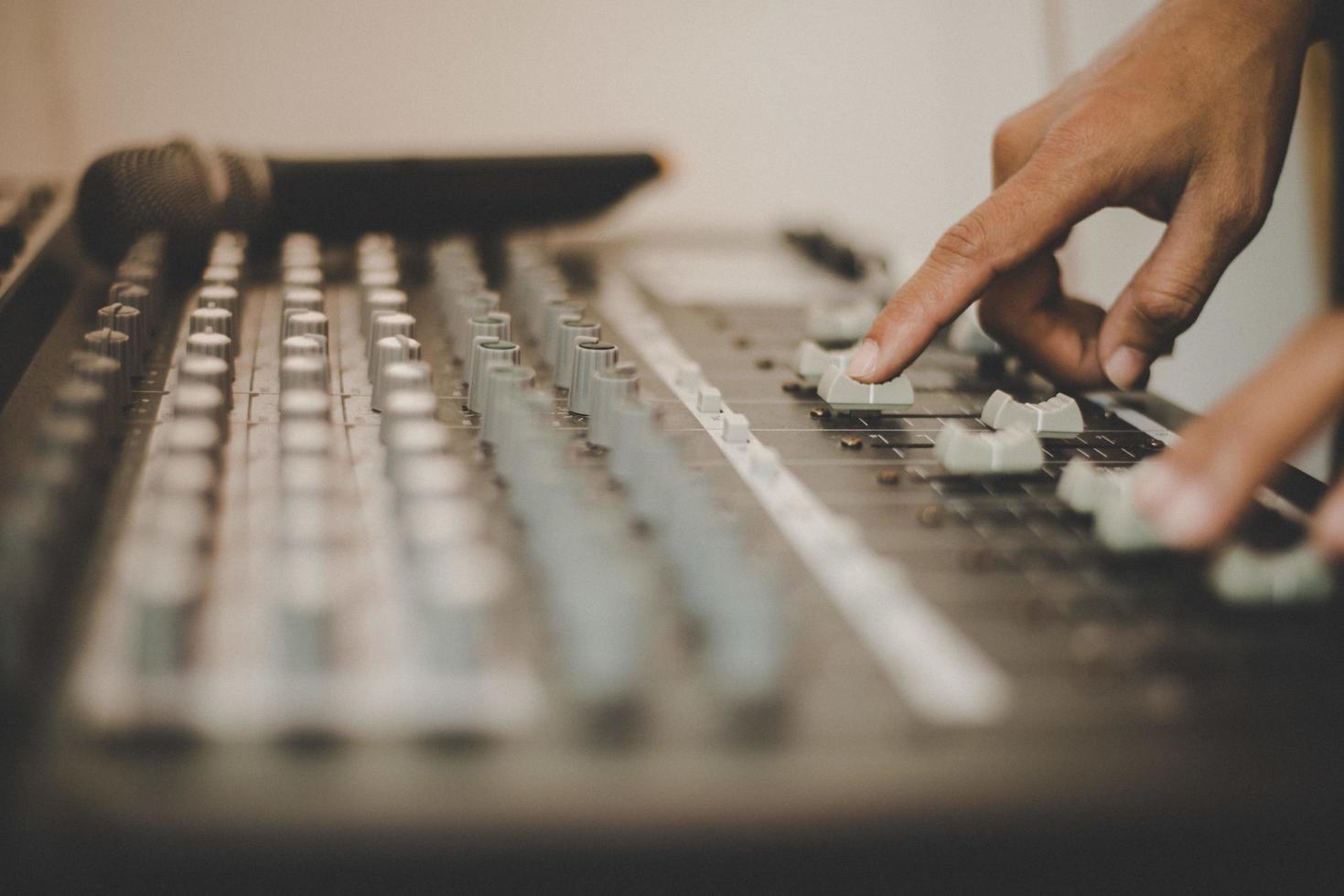 Hands of sound engineer adjusting audio mixing console photo