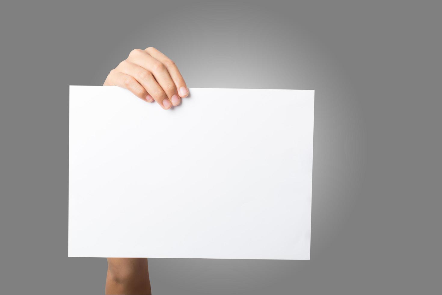 Close-up de la mano de una mujer sosteniendo papel en blanco aislado sobre fondo blanco. foto