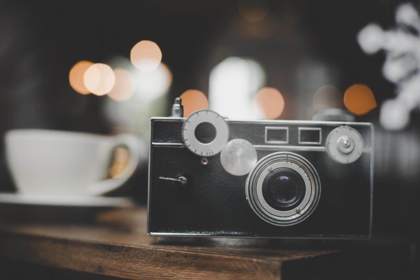 Vintage or retro camera on a wooden table at a cafe photo