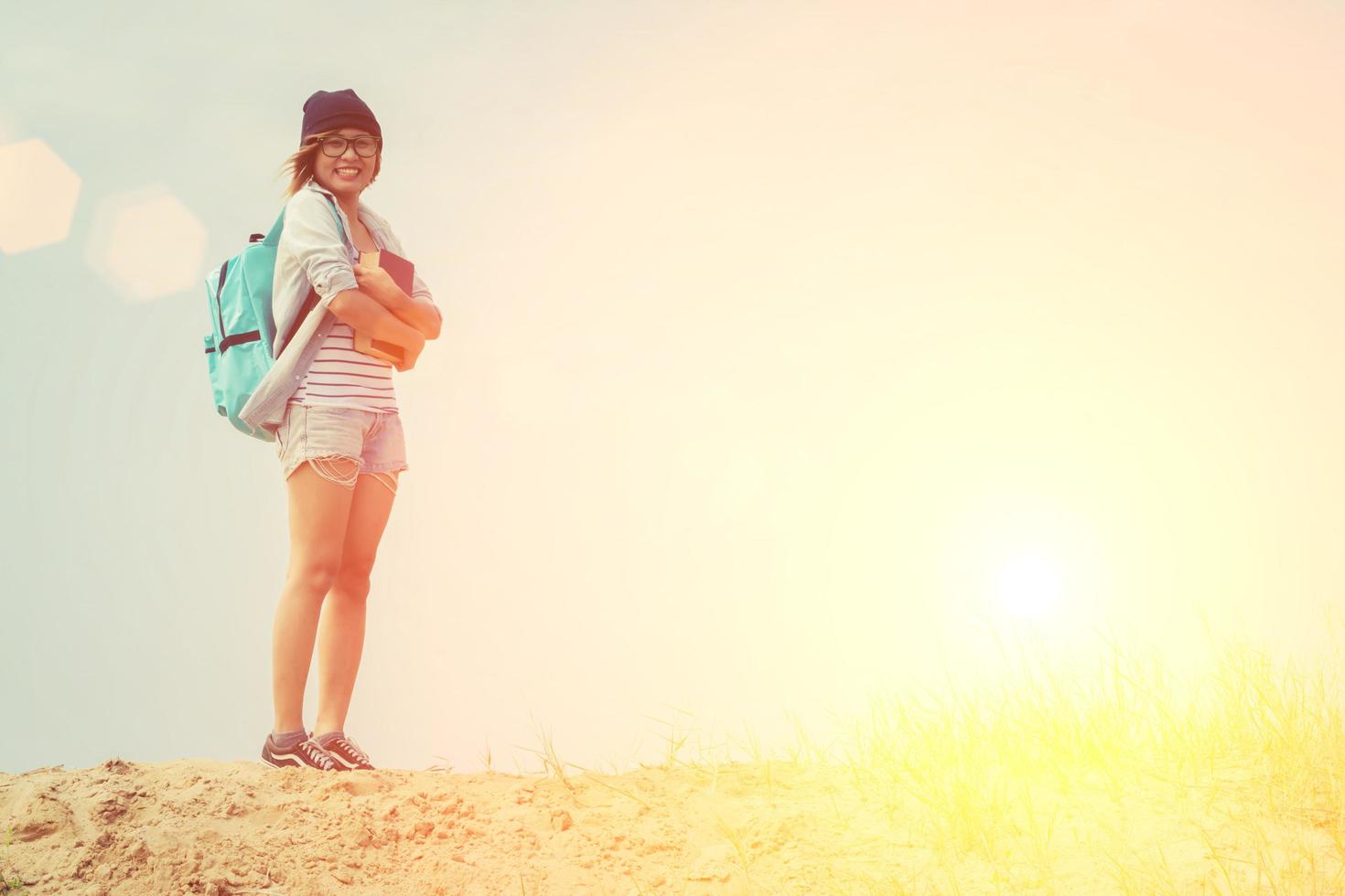 Young hipster woman holding a book below the sky photo