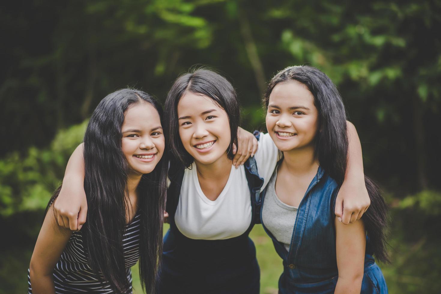 Happy teenage friends smiling outdoors at a park photo